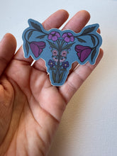 Load image into Gallery viewer, Teal floral uterus sticker in detailed giclée style—blending body anatomy with blooming wildflowers in a feminist botanical illustration.
