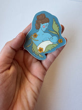 Load image into Gallery viewer, Tender vinyl matte sticker featuring a mother cradling her baby, illustrated with soft vintage colors and emotional warmth.