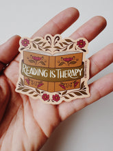 Load image into Gallery viewer, Vintage-inspired vinyl matte sticker with the phrase &#39;Reading Is Therapy&#39; adorned with floral elements.