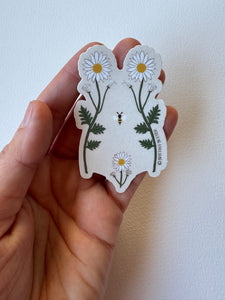 Delicate sticker illustrating a woman’s torso with blooming wildflowers in vintage style—celebrating body positivity and nature’s strength.