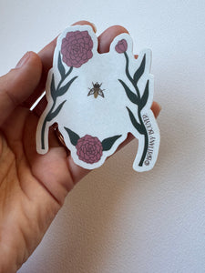Delicate sticker illustrating a woman’s torso with blooming wildflowers in vintage style—celebrating body positivity and nature’s strength.