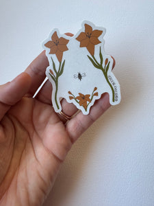 Delicate sticker illustrating a woman’s torso with blooming wildflowers in vintage style—celebrating body positivity and nature’s strength.
